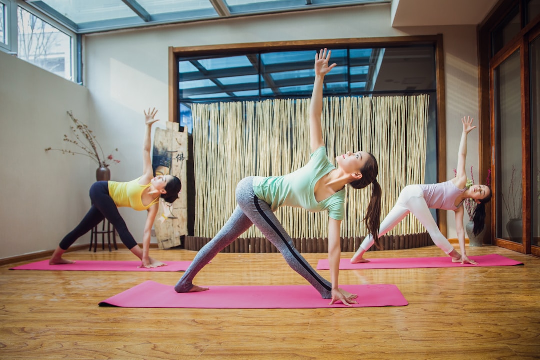 Woman practicing yoga on a mat in a bright studio environment, demonstrating stability and focus.