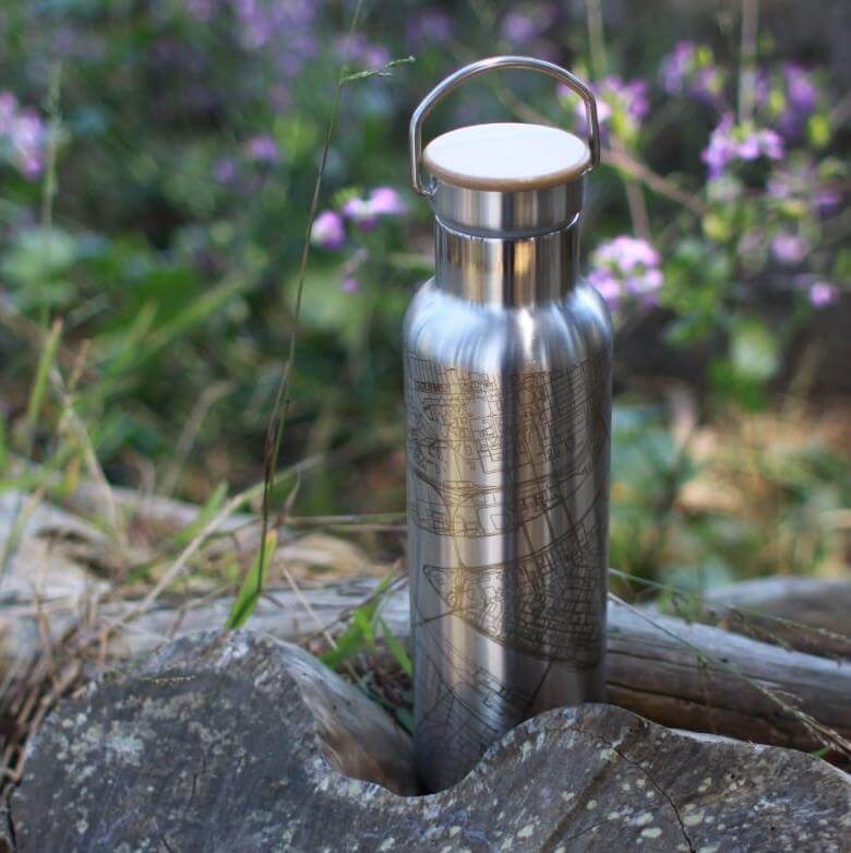 Athens, Georgia map engraved stainless steel bottle with bamboo top, set against a natural background of flowers.