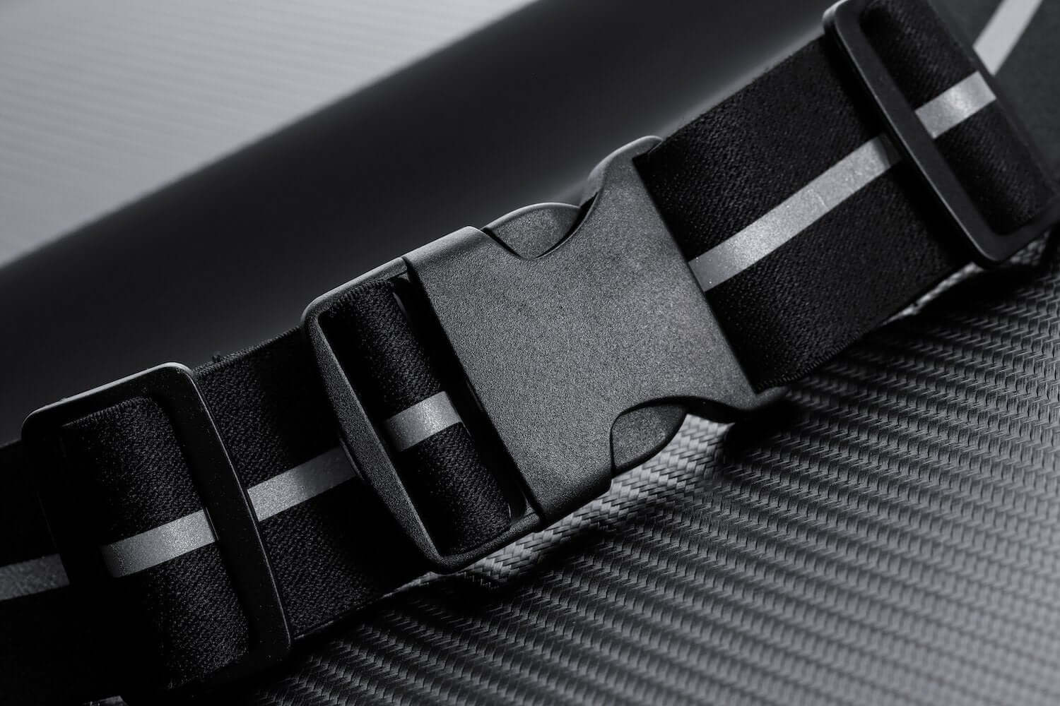 Close-up of a black sport waist pack running belt with reflective strip and buckle detail, ideal for workouts.