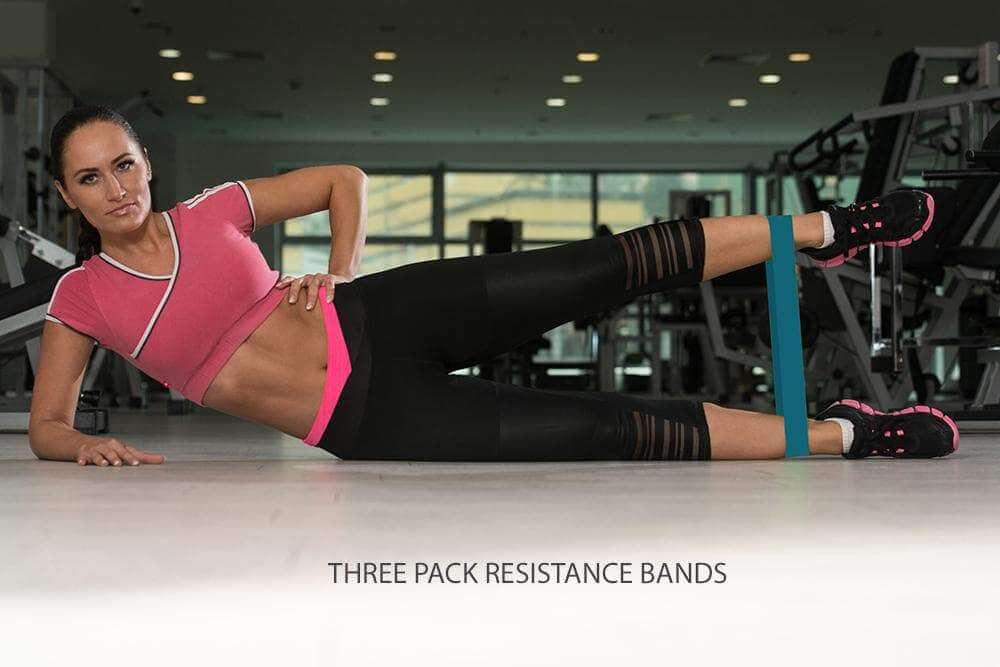 Woman using three pack resistance bands for leg workouts in a gym setting, promoting muscle recovery and flexibility.